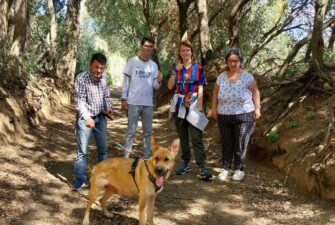 Grup d'usuàries passejant un gos del centre d'acollida.